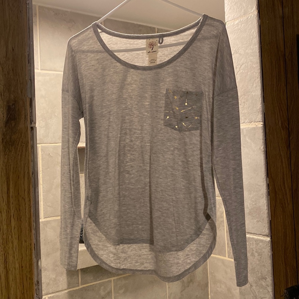 Woman’s size M. Light grey with gold arrows on breast pocket. Long sleeve.